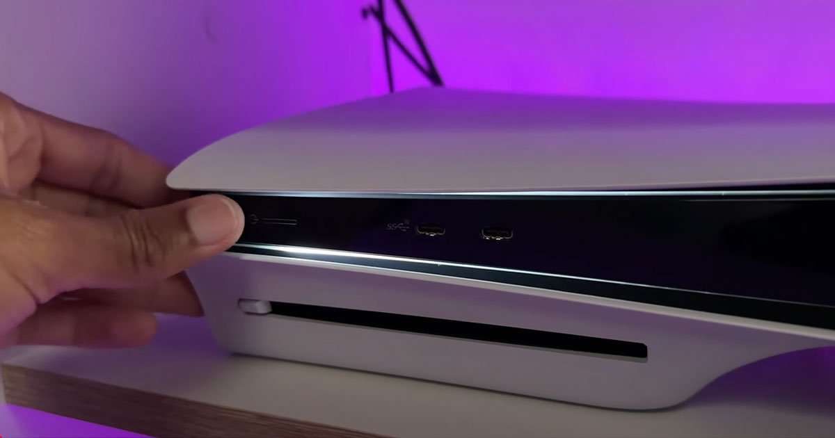 Mano apagando una consola PS5 desde el botón frontal.